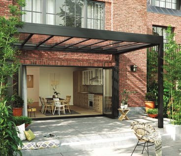 Terrasse couverte en aluminium contre une façade en brique