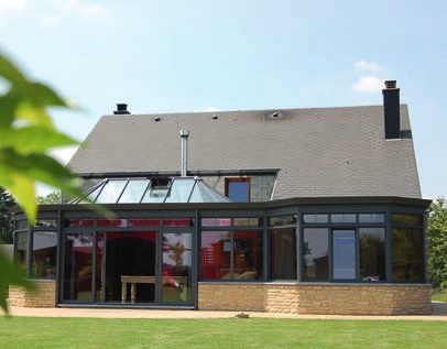 Véranda vitrée adossée à une maison ancienne