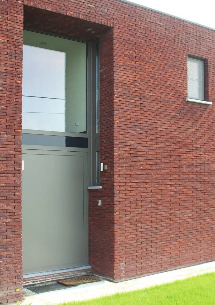 Porte d’entrée sur mesure sur un mur en brique rouge